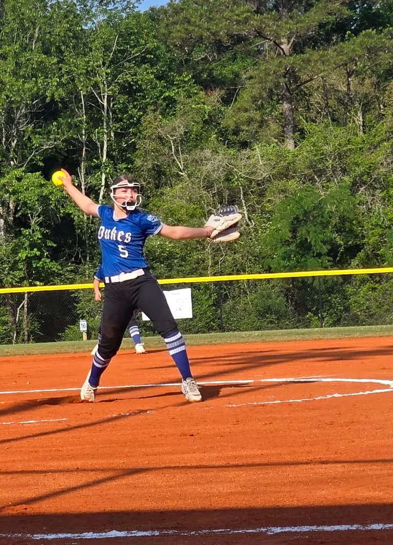 Alexis Arnold dealing a pitch for the Lady Dukes, ball in hand.